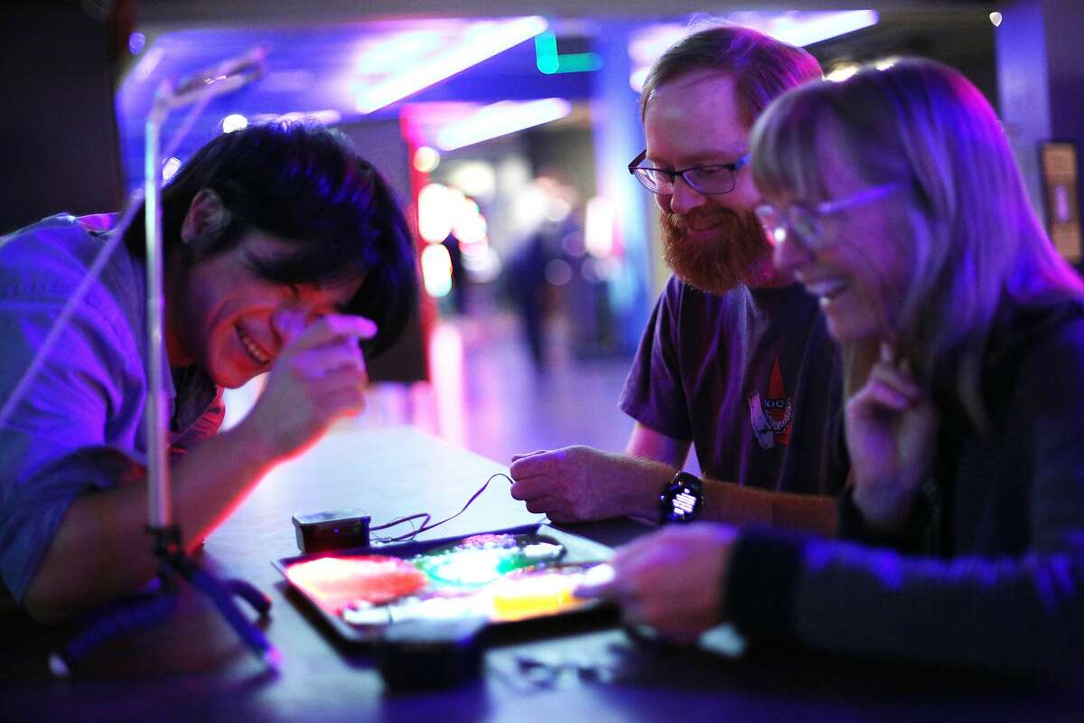 From left: "Slime Lamps / SIProp" artists Hirotaka Niisato with visitors Jesse Wagstaff and Mary Wagstaff during the Maker Faire preview at The Exploratorium, Thursday, May 17, 2018, in San Francisco, Calif.