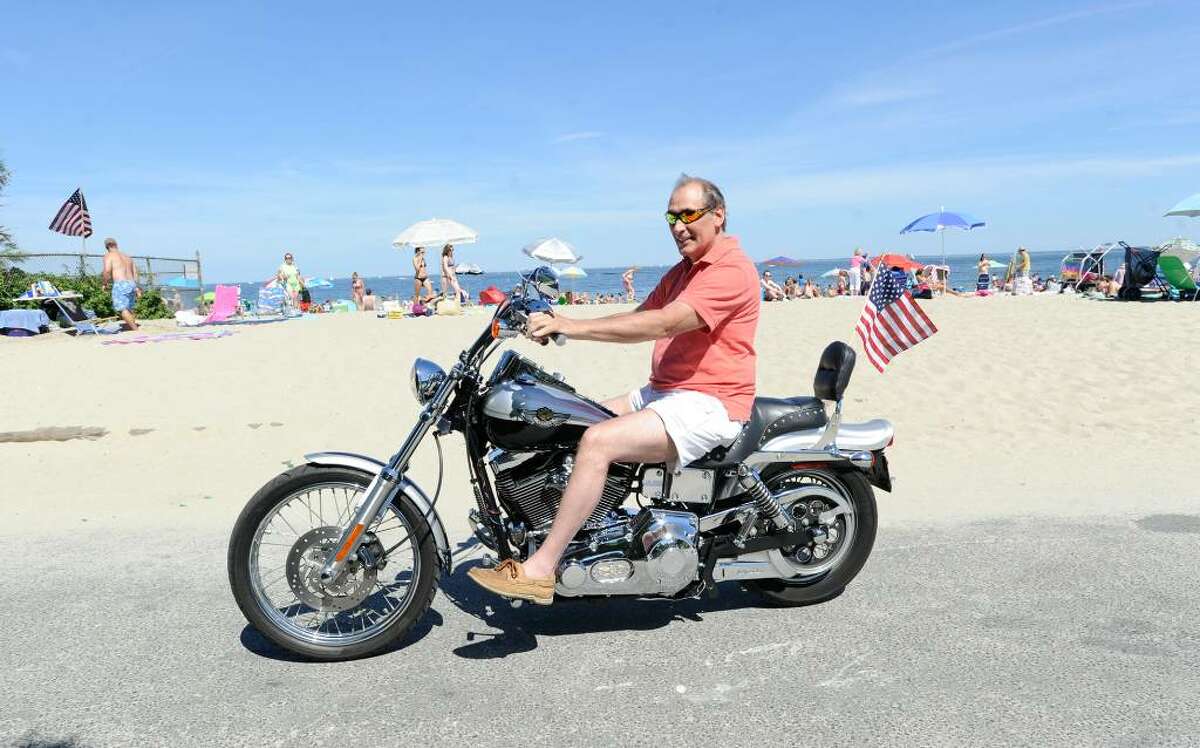 Rick Garbarini of Riverside rides his Harley-Davidson motorcycle with American flag flying at Greenwich Point, Saturday afternoon, July 3, 2010.