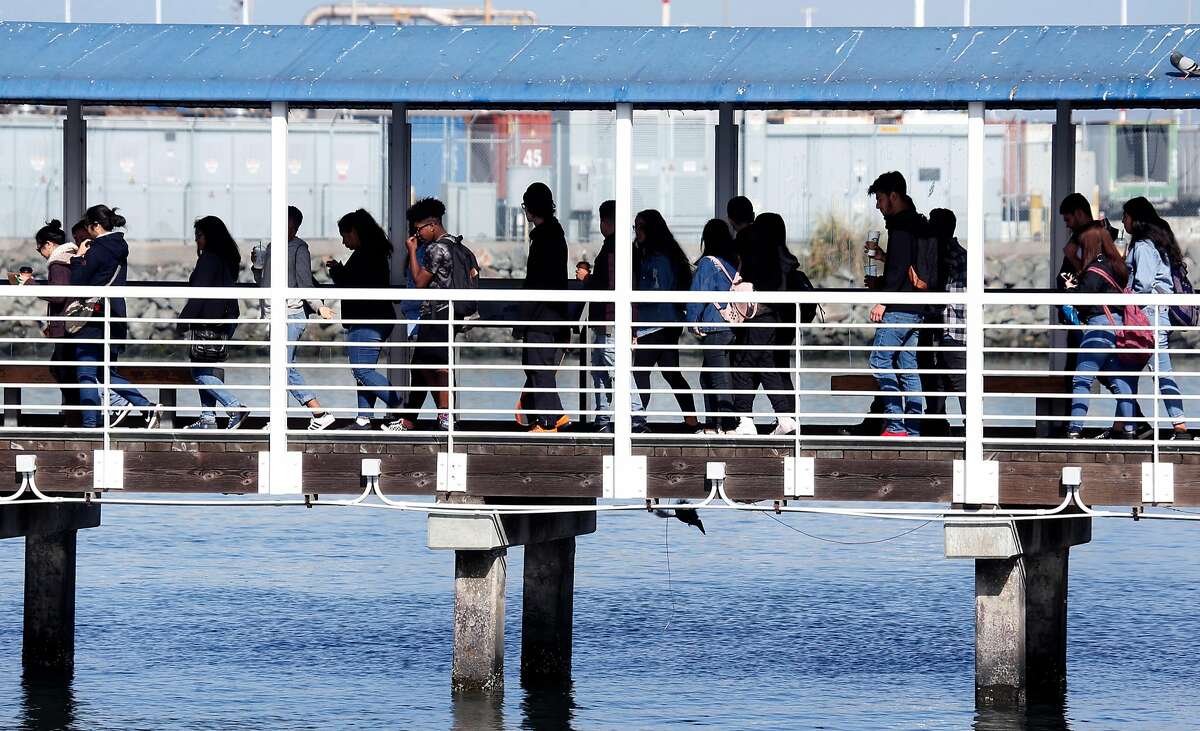 Commuters board a ferry to San Francisco in Oakland, Calif. on Thursday, May 10, 2018. Ferry service would be upgraded if voters approve Regional Measure 3 which would raise area bridge tolls, except on the Golden Gate Bridge, to fund transportation projects throughout the Bay Area.