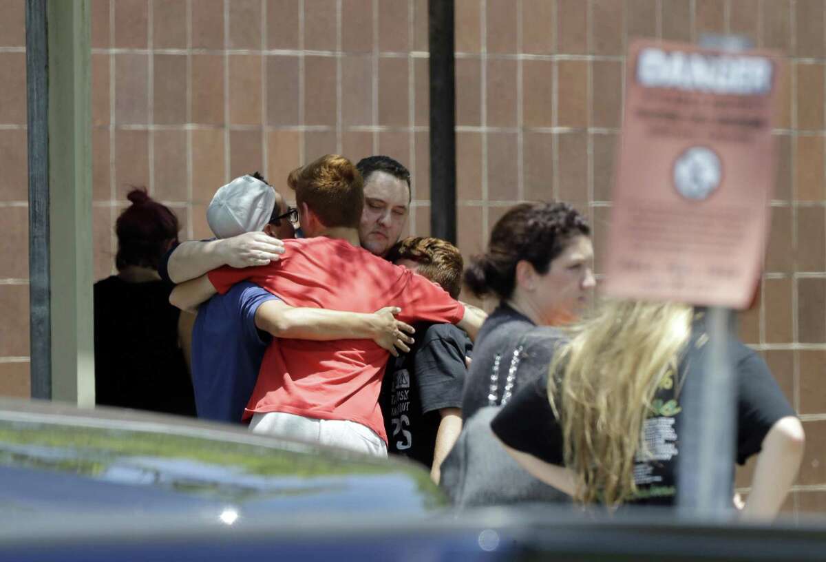 People react outside the unification center at the Alamo Gym, following a shooting at Santa Fe High School Friday, May 18, 2018, in Santa Fe, Texas. (AP