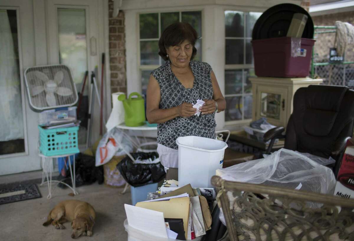 Irene Tamacho goes over documents and old photographs that got damage by the floods caused by Hurricane Harvey.