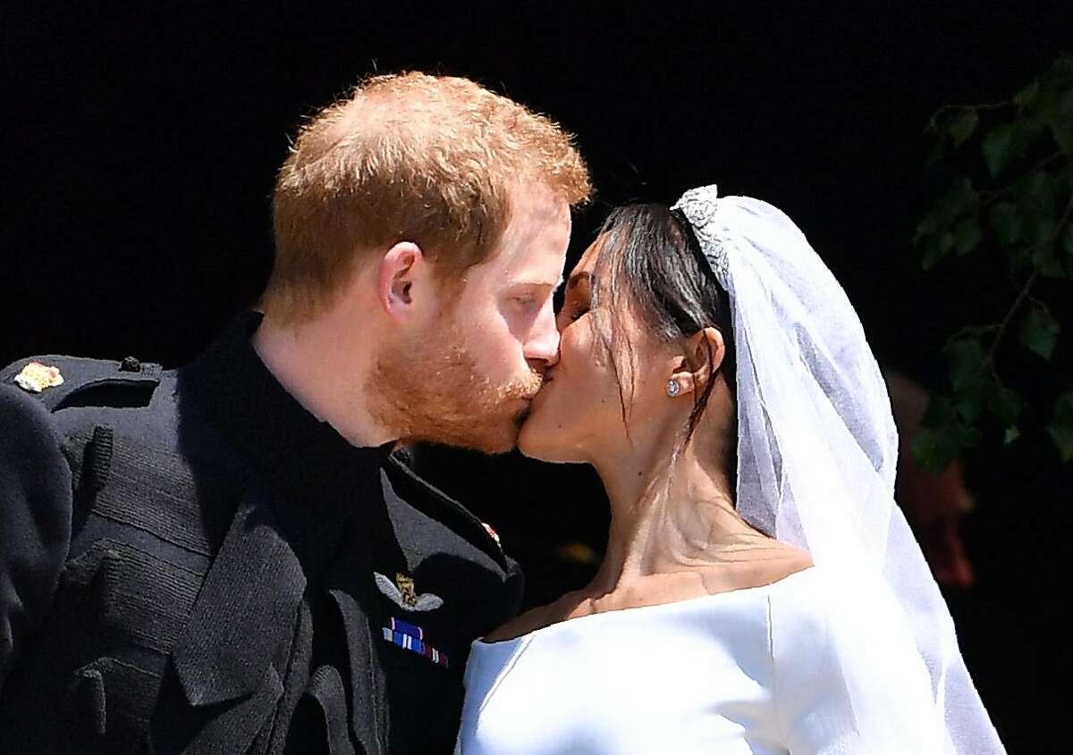 TOPSHOT - Britain's Prince Harry, Duke of Sussex kisses his wife Meghan, Duchess of Sussex as they leave from the West Door of St George's Chapel, Windsor Castle, in Windsor, on May 19, 2018 after their wedding ceremony. / AFP PHOTO / POOL / Ben STANSALLBEN STANSALL/AFP/Getty Images