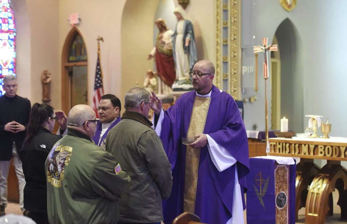 Father Arthur Mollenhauer performs his duties at the Ash Wednesday service at St. Roch's Church in the Chickahominy section of Greenwich on Feb. 14.