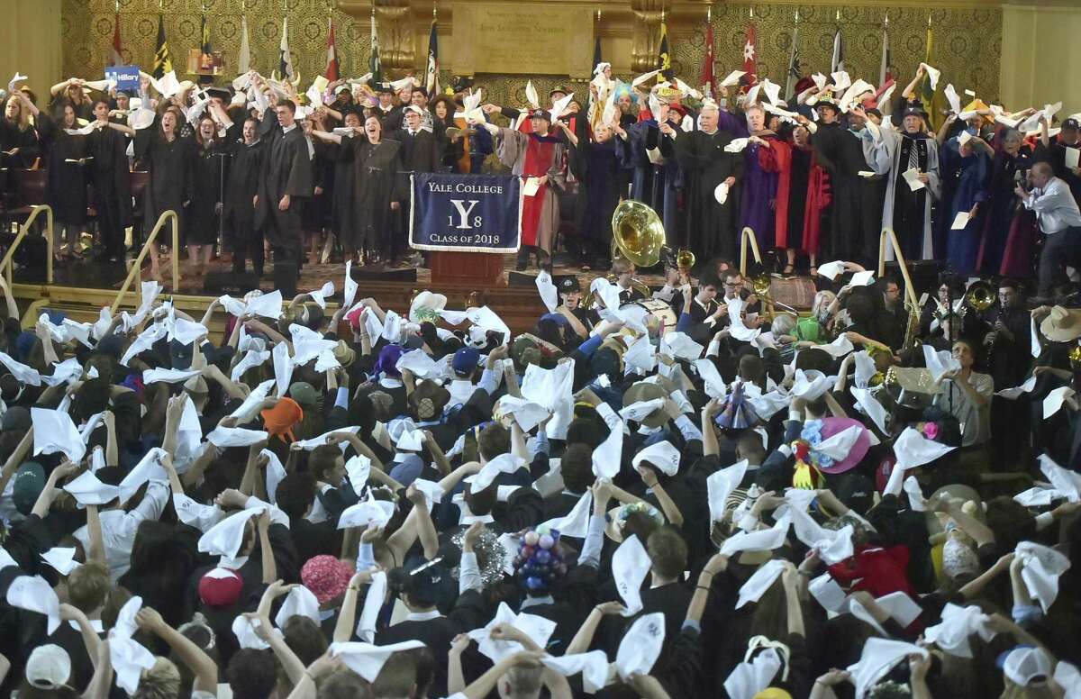 New Haven, Connecticut - Sunday, May 20, 2018: Yale University's Class Day concludes at Woolsey Hall in New Haven as the Yale College class of 2018, faculty and guests wave the Yale Handkerchief during the singing of the last line of "Bright College Years," a custom inaugurated by the Class of 1984