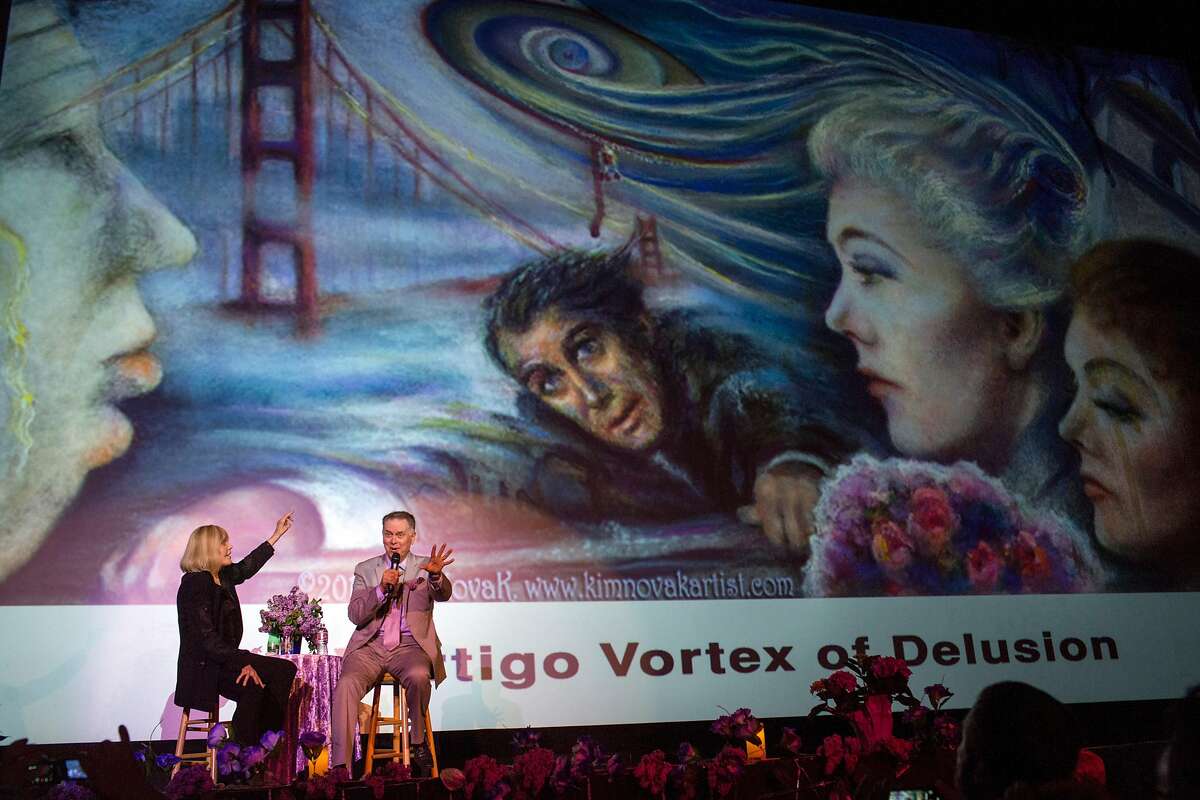 The host, Eddie Muller interviews Kim Novak on stage during an event in her honor "A Tribute to Living Legend Kim Novak" at the Castro Theater. The image on the screen behind them is one of Novak's paintings depicting the film Vertigo. On Sunday, May 20, 2018. San Francisco Calif.