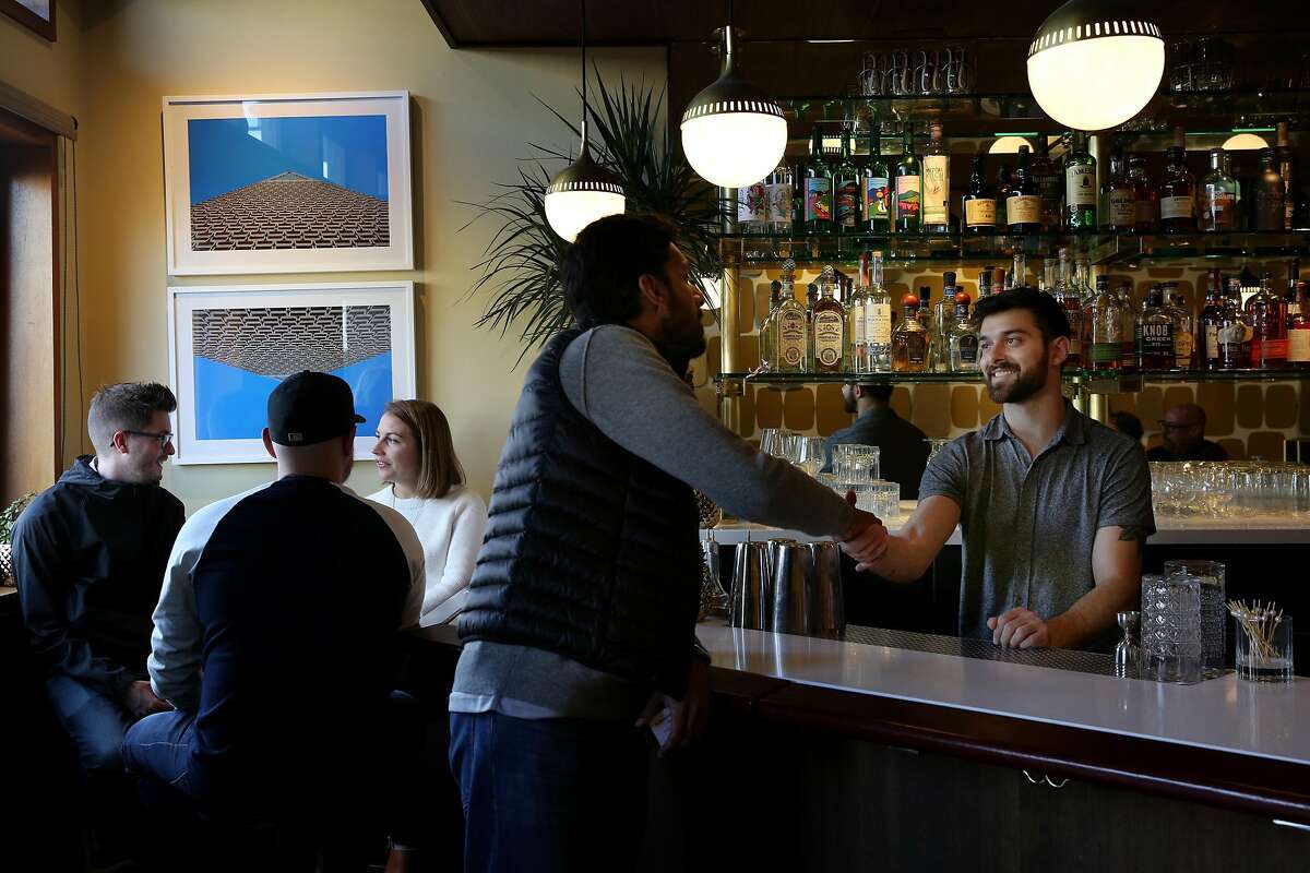 Arjun Venkatesh (center) greets bartender Emilio Salehi at The Beehive, Saturday, May 5, 2018, in San Francisco, Calif. It's located at 842 Valencia Street.