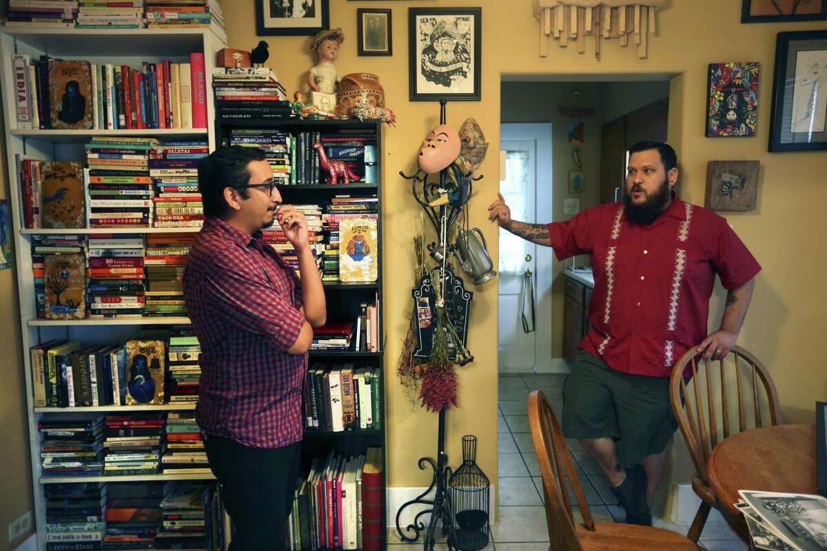 Stephen, left, and Fred Garza-Guzman talk in their home about their paranormal object collection.