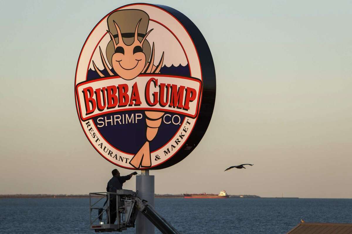 FILE - Gilbert Lopez puts a fresh coat of paint on the Bubba Gump Shrimp Co. pole outside the Kemah Boardwalk restaurant on Feb. 13, 2013, in Kemah. JP Morgan Chase Bank is suing Landry's, the Houston-based hospitality company, for $20 million over costs related to its 2015 credit card data breach.