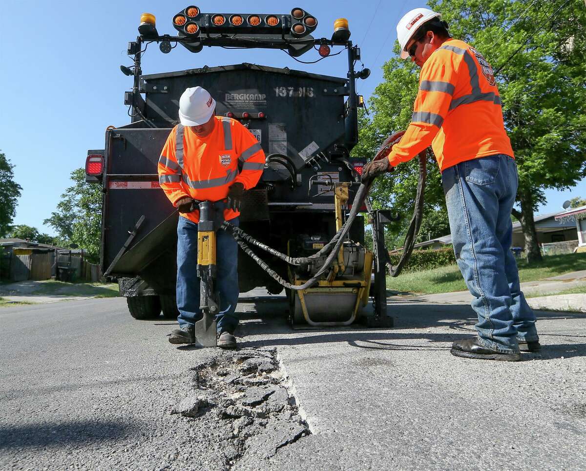 Jesse Cisneros (left) and Ramiro Sanchez with the city's Transportation and Capital Improvements work to repair a pothole on Yolanda Street last year. The TCI crews repaired a record 100,000 potholes for the 2019 fiscal year. MARVIN PFEIFFER/mpfeiffer@express-news.net