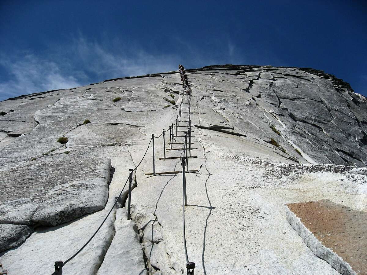 Hikers enjoy climbing alongside the cables on Half Dome during the summer of 2009. A group is fighting Yosemite National Park�s policy that limits the number of hikers on the final 400-foot climb up Half Dome. They say Americans have a right to freely enjoy nature. The park service began limiting the number of hikers on the enormous sliced-in-half granite dome in 2010 to combat regular bottlenecks.