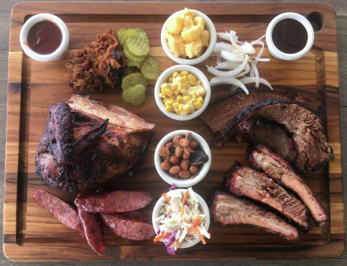 The barbecue board at True Texas BBQ includes (clockwise from top left) pulled pork, mac and cheese, creamed corn, brisket, pork ribs, coleslaw, brisket beans, sausage and a white meat chicken breast quarter.