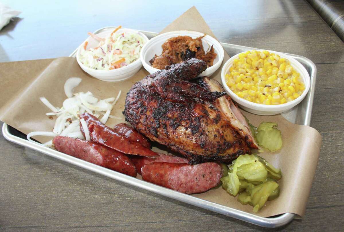 The three-meat plate ($14.79) comes with two sides. Pictured are sausage, pulled pork (middle dish) and a white meat breast quarter with coleslaw and creamed corn.