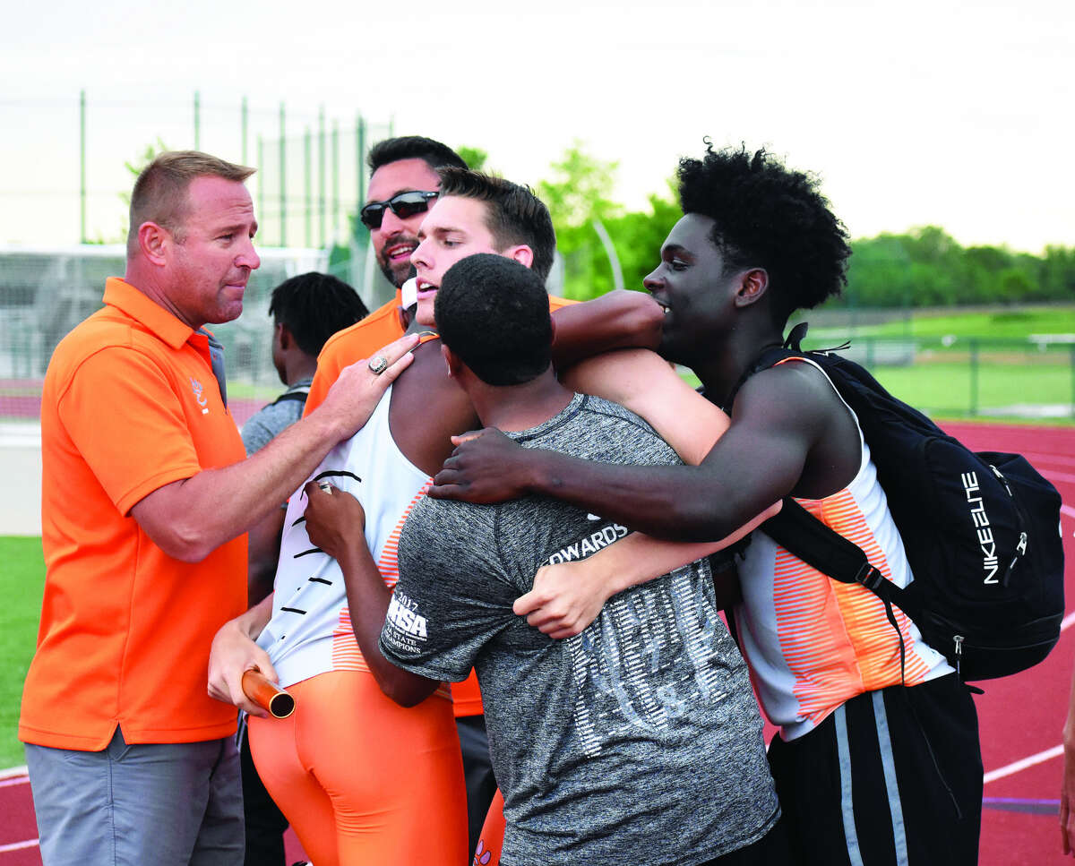 EHS coach Chad Lakatos, left, and members of the track and field team celebrate with Ben Ryan after the 1,600-meter relay team qualified for state.