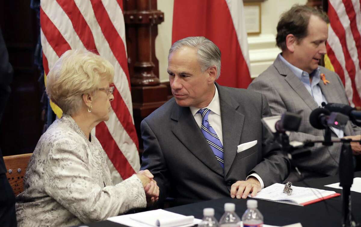 Alice Tripp, Legislative Director of the Texas State Rifle Association, left, shakes hand with Texas Gov. Gregg Abbott, center, following a roundtable discussion to address safety and security at Texas schools in the wake of the shooting at Santa Fe, at the State Capitol in Austin, Texas, Wednesday, May 23, 2018. Ed Scruggs, Board Vice-Chair of Texas Gun Sense, is at right. Abbott, a Republican who has worked to expand gun rights in the state, called for the meetings as he weighs ideas for possible legislative action or executive orders. Two dozen groups were invited to attend the session, which was expected to include conversations on monitoring students' mental health. (AP Photo/Eric Gay)