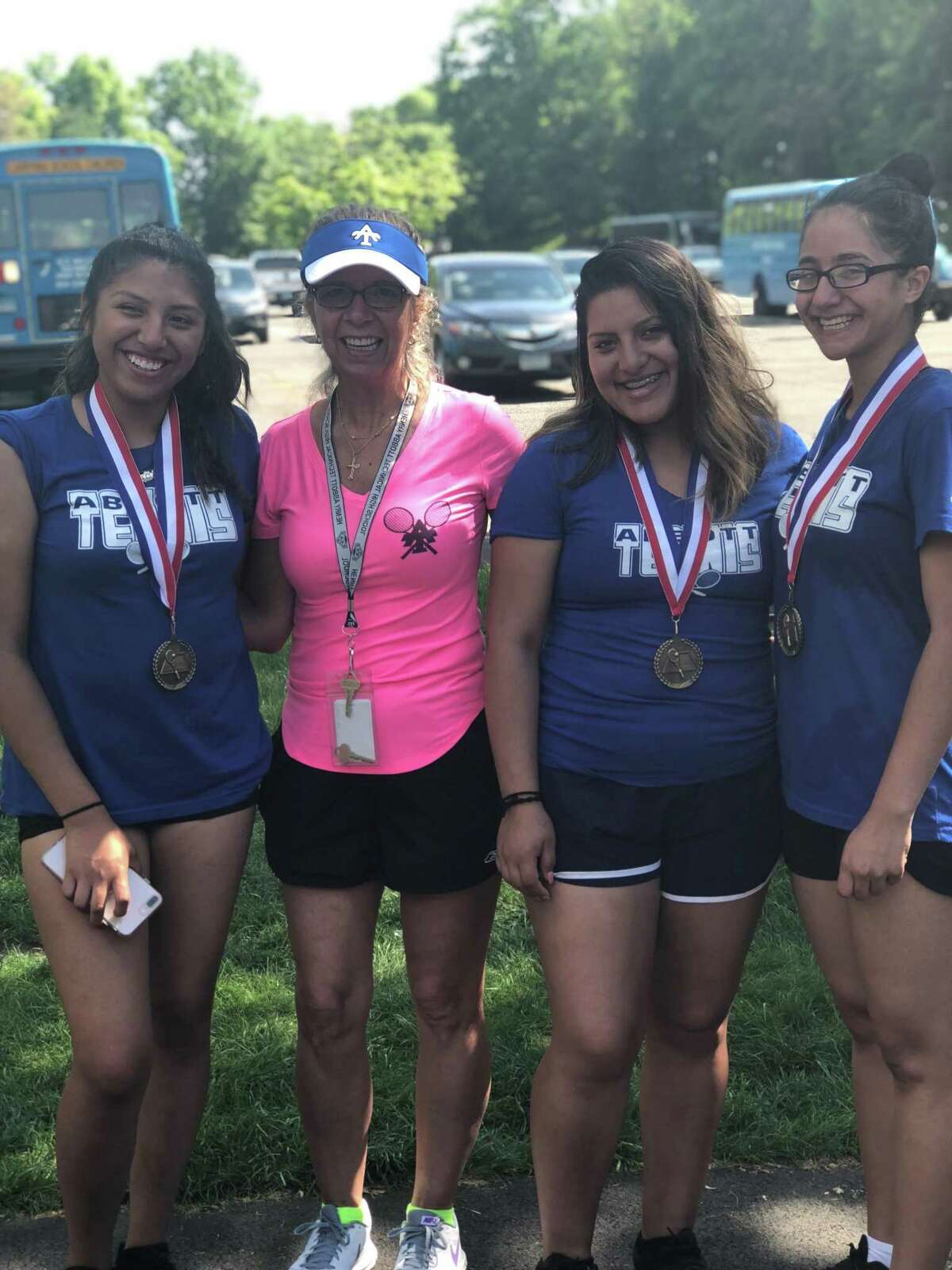 Abbott Tech tennis players Ebelin Lalvay (left), Karen Pelaez (second from right) and Jesslyn Rodriguez (right), along with coach Shelley Visinski at the CTC championships, held at Wesleyan University in Middletown May 23, 2018.