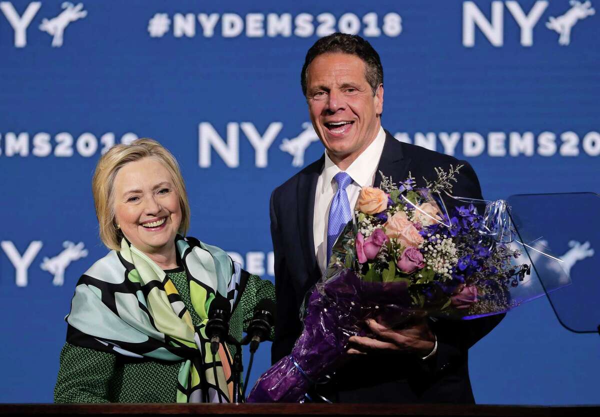 Former Secretary of State and former Democratic Presidential candidate Hillary Clinton, left, is greeted by Gov. Andrew Cuomo after speaking during the New York state Democratic convention after being greeted by New York Gov. Andrew Cuomo, Wednesday, May 23, 2018, in Hempstead, N.Y. (AP Photo/Julie Jacobson)
