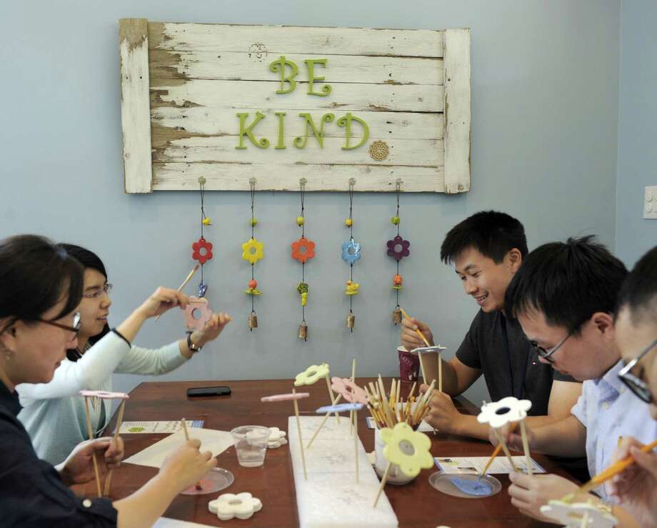 Summer interns at Boehringer Ingelheim, paint flowers that will be used in the making of Ben's Bells, Wednesday, July 29, 2015. Ben's Bells has outgrown its Newtown space and is moving to a new building in Bethel. They include from left, Yiyi Chu, Hee-Koung Joeng, Xiaoqi Lu, Guan Yu and Yaohua Zhang. Photo: Carol Kaliff / Hearst Connecticut Media / The News-Times
