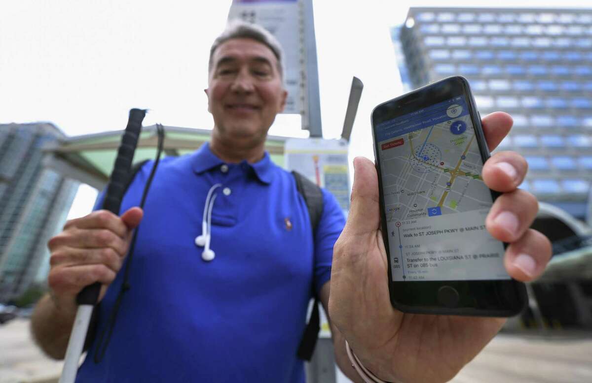 Michael McCulloch, 63, a member of the test group that helps Metropolitan Transit Authority experiment with Bluetooth beacons, poses with an app-in-progress that he is assisting to develop for visually-impaired passengers at a bus stop on May 24.