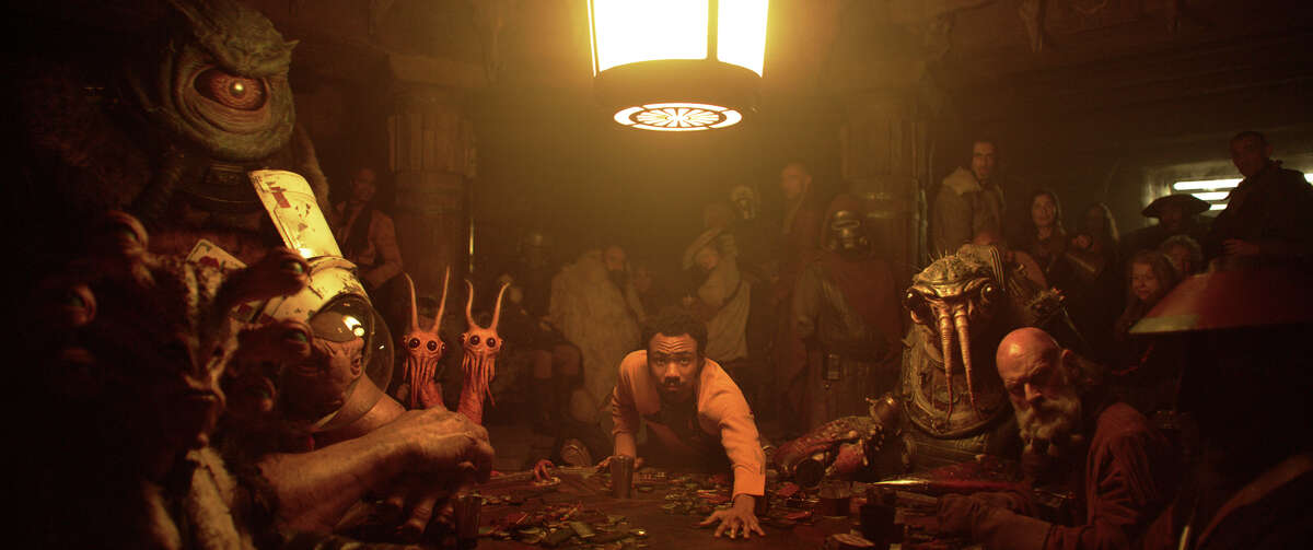 This image released by Lucasfilm shows Donald Glover as Lando Calrissian, center, in a scene from "Solo: A Star Wars Story." (Lucasfilm via AP)
