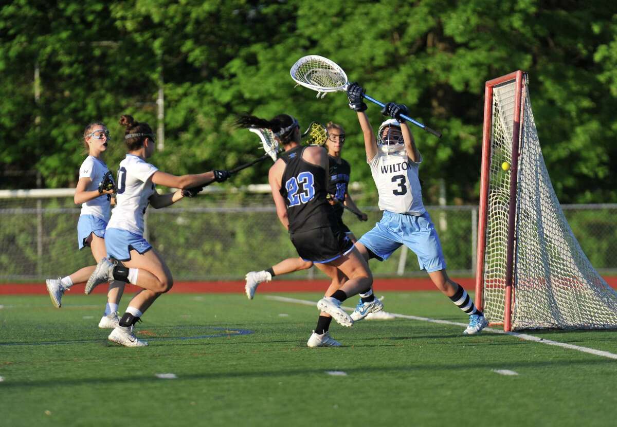 Maddie Joyce (23) of the Darien Blue Wave shoots and scores during the FCIAC Championship Game against the Wilton Warriors on Thursday May 24, 2018, in Norwalk, Connecticut.