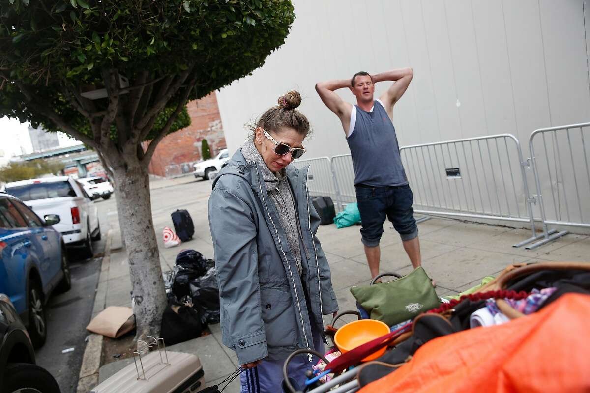 Krystle Erickson (l to r) and Brian Kitchng pack a cart with their belongings as they relocate from Utah Street on Friday, May 25, 2018 in San Francisco, Calif.