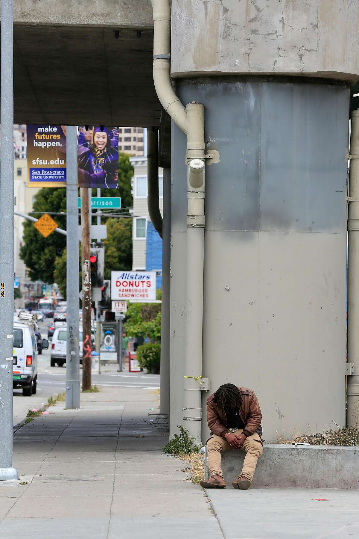 A person sits along 5th Street between Howard and Bryant currently devoid of tents on Friday, May 25, 2018 in San Francisco, Calif.