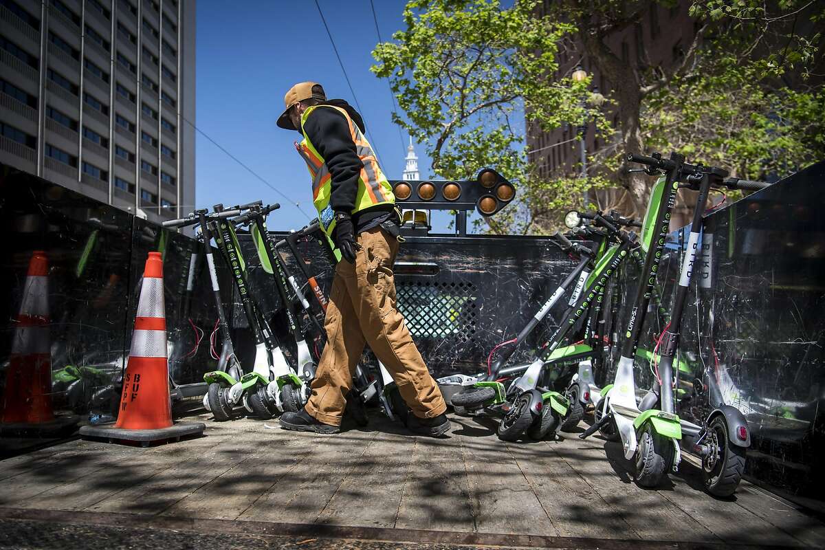 A City of San Francisco Public Works employee loads a Neutron Holdings Inc. LimeBike shared electric scooter onto the back of a truck in San Francisco, California, U.S., on Wednesday, May 2, 2018. City officials, eager to do something about the electric scooters issue, are sending cease-and-desist letters and are planning to require permits soon, while impounding any that they say are parked illegally. Photographer: David Paul Morris/Bloomberg