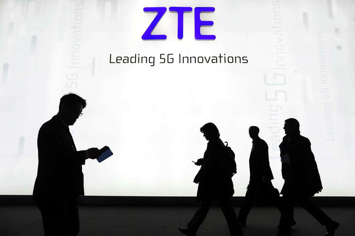 Attendees pass by the ZTE Corp. stand at the Mobile World Congress (MWC) in Barcelona on Feb. 26, 2018.