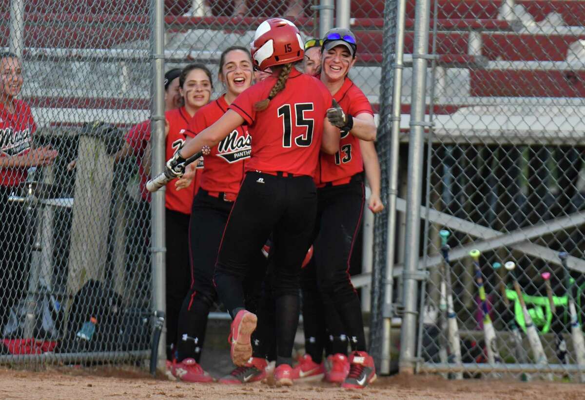 Masuk’s Erica Pullen is congratulated by her teammates after scoring the first run during the SWC championship game against Newtown on Friday at DeLuca Field in Stratford.