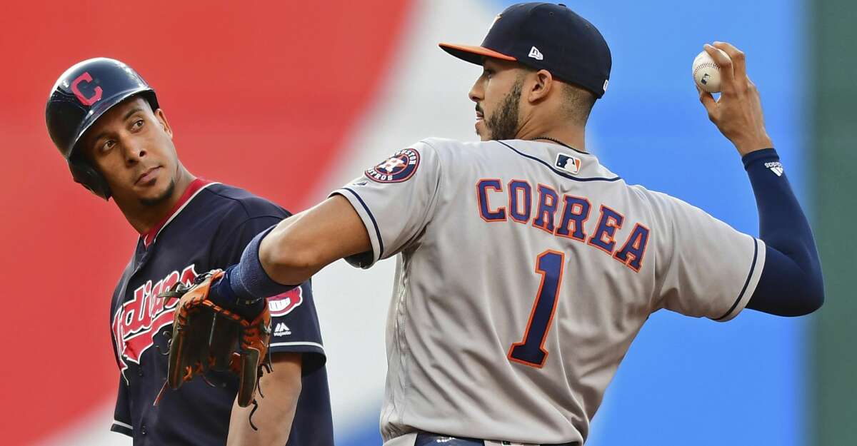 Cleveland Indians' Michael Brantley looks over at Houston Astros' Carlos Correa after Brantley hit a double during the third inning of a baseball game Friday, May 25, 2018, in Cleveland. (AP Photo/David Dermer)