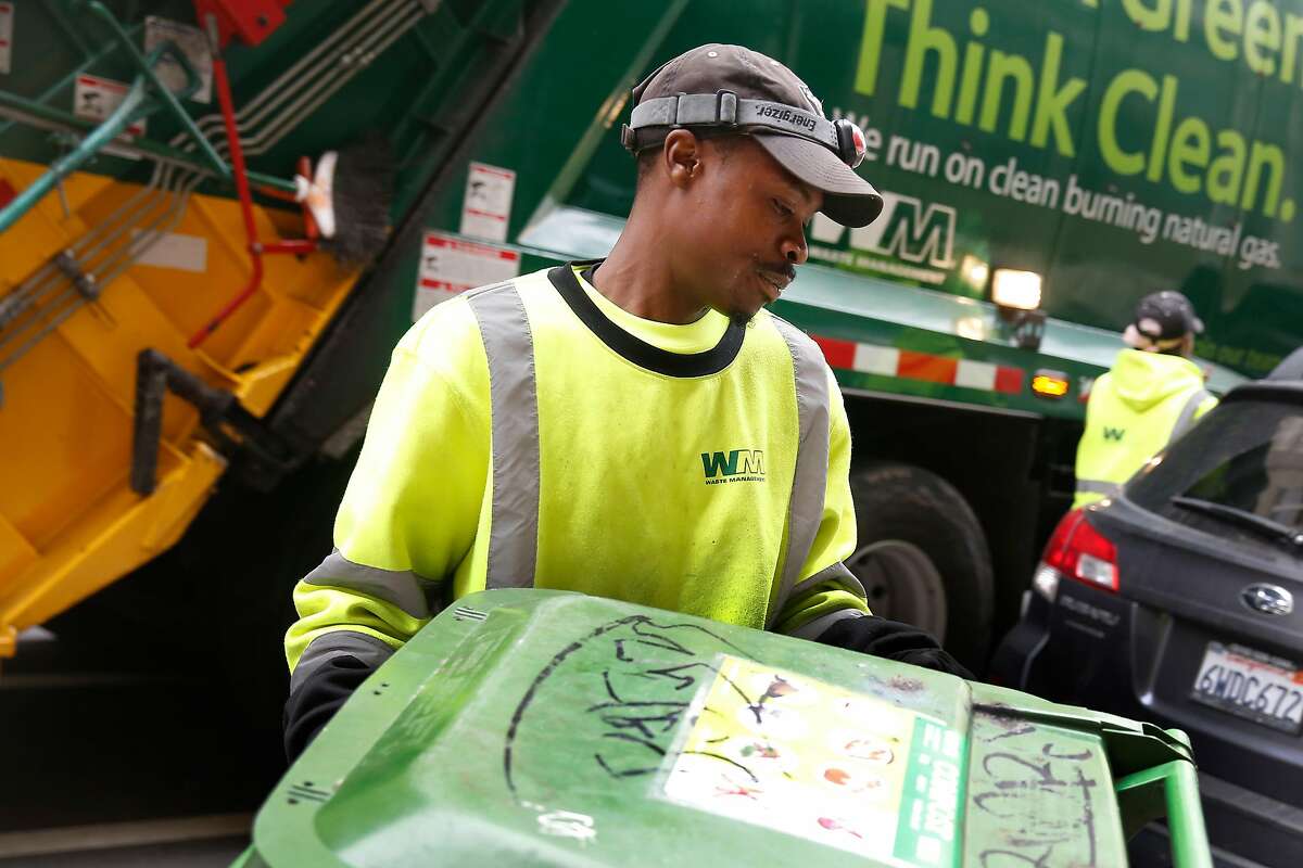 Khris Bland, Teamster apprentice at Waste Management of Alameda County, Inc. (WMAC), empties waste management bins while working on Thursday, May 24, 2018 in Oakland, Calif.