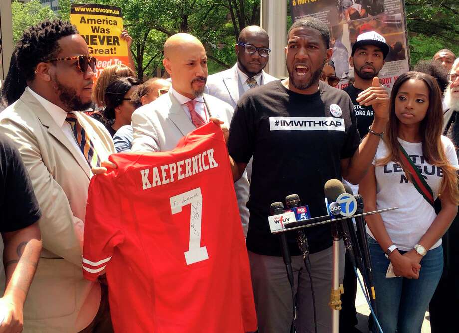 New York Councilman Jumaane D. Williams, second from right, with the help of  Kirsten John Foy, second from left, Northeast Regional Director of the National Action Network, holds a jersey with Colin Kaepernick's name on the back, during a rally of civil rights activists outside of the NFLs headquarters, Friday, May 25, 2018, in New York. About 50 people gathered to protest the NFLs new policy aimed at ending player protests during the playing of the national anthem in stadiums before games. Kaepernick, the former San Francisco 49ers quarterback, started the movement of taking a knee during the anthem to protest police brutality and racial inequality two seasons ago. (AP Photo/Ralph Russo) Photo: Ralph Russo / AP