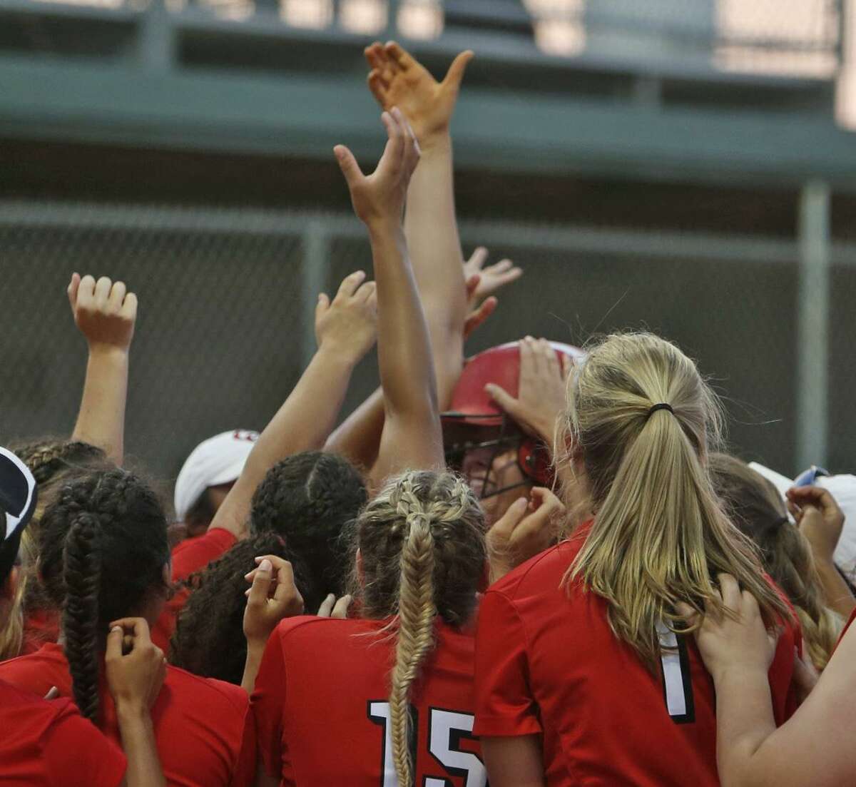 New Braunfels Canyon’s Brooke Vestal is swarmed by teammates after her fourth inning HR in the Region IV-6A high school softball final between New Braunfels Canyon and Warren at Southwest High School on Friday, May 25, 2018.