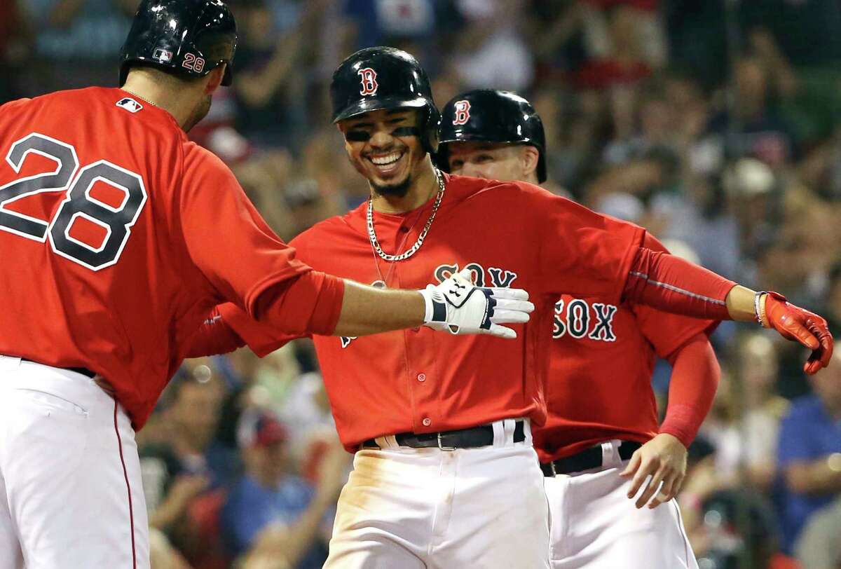 Boston Red Sox's Mookie Betts celebrates with J.D. Martinez (28) after hitting a two-run home run in the seventh inning of an inter-league baseball game against the Atlanta Braves at Fenway Park, Friday, May 25, 2018, in Boston. (AP Photo/Elise Amendola)