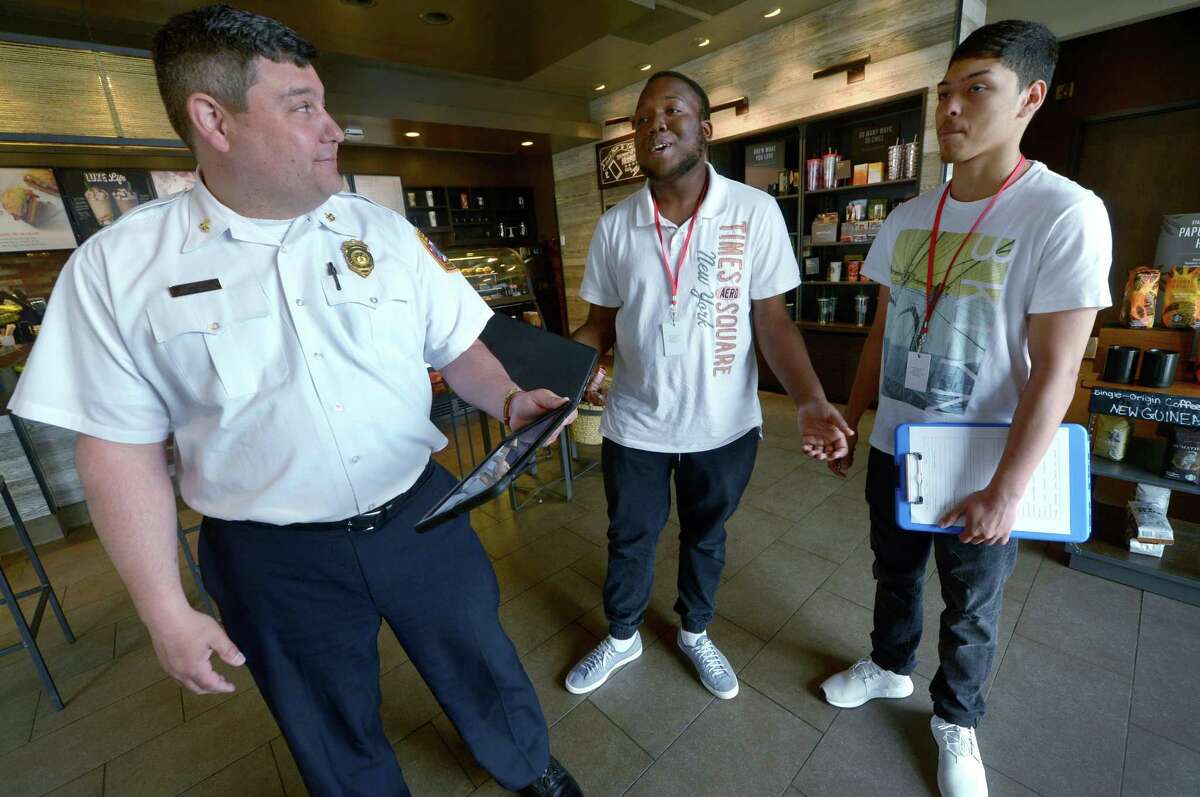 Deputy Fire Chief Al Bassett accompanies Brien McMahon High School students Malik Scott and Johan Mena while assisting with pre-fire planning survey at establishments in Darinor Plaza Tuesday, May 22, 2018, as the students begin their four week internship at the Norwalk Fire Department.
