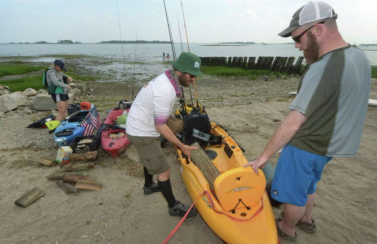 Beth and Jason Peyser of Ridgefield and Jon Ringel of Norwalk prepare to paddle out to Cockenoe Island in Westport to camp for the Memorial Day weekend as they assemble their gear at Calf Pasture Beach Saturday, May 26, 2018, in Norwalk, Conn.