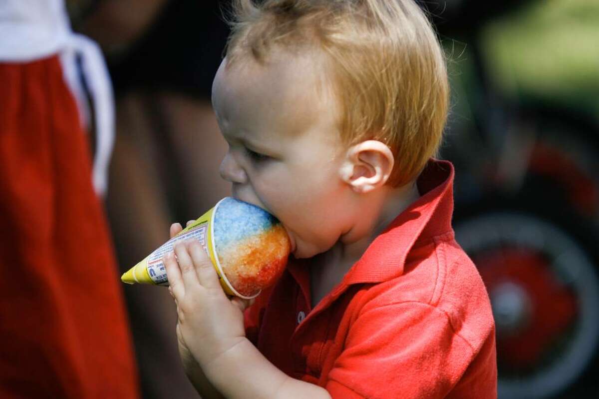Reed Martinsen, age 1, bites into a snow cone at the Pequot Library's Independence Day festivities in Southport on Sunday, July 4, 2010.