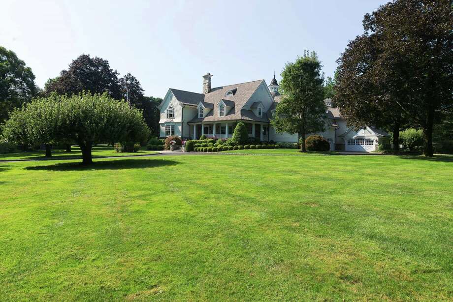 The custom clapboard and stone colonial house at 499 Silvermine Road sits on a two-acre level property and has a wealth of amenities for indoor-outdoor living. Photo: Stanley Jesudowich /Contributed Photos / Stanley Jesudowich