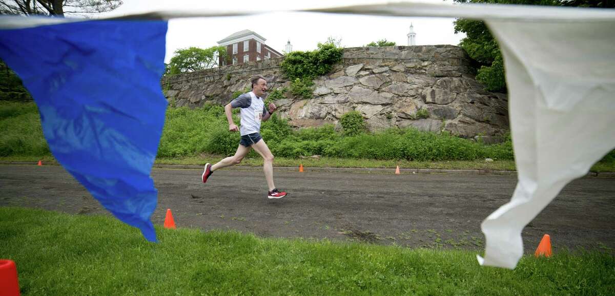 Stuart Allen, 55, of Greenwich, Conn., finishes the Jim Fixx Greenwich Memorial Day Five Mile Road Race in Greenwich, Conn., on Monday, May 28, 2018.