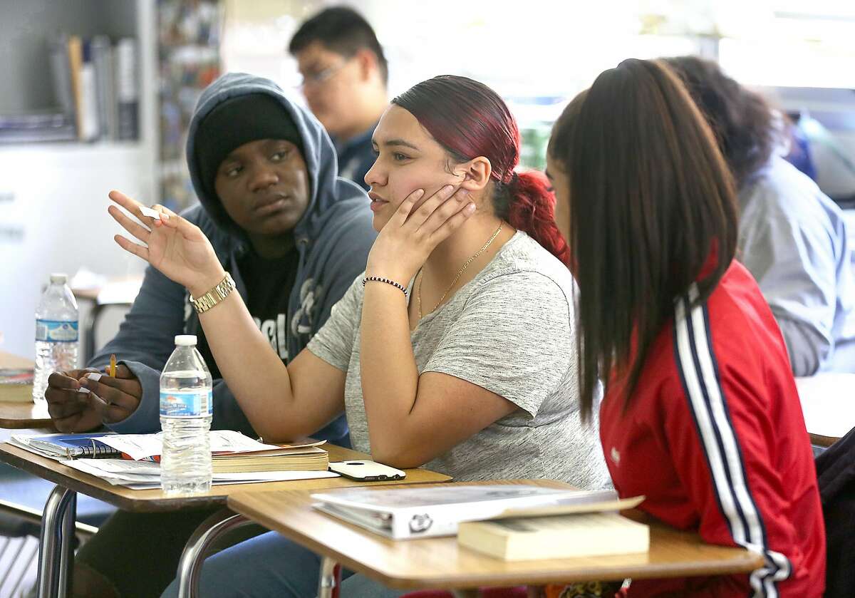 Castlemont High School seniors Amoy Tomlin (left), 17 years old, America Sanchez (middle), 17 years old, and Cynthia Galvan (right), 17 years old, take an English 4 class on Tuesday, May 8, 2018 in Oakland, Calif. District officials released a report today on the impact of charter schools on the district at Castlemont High School.