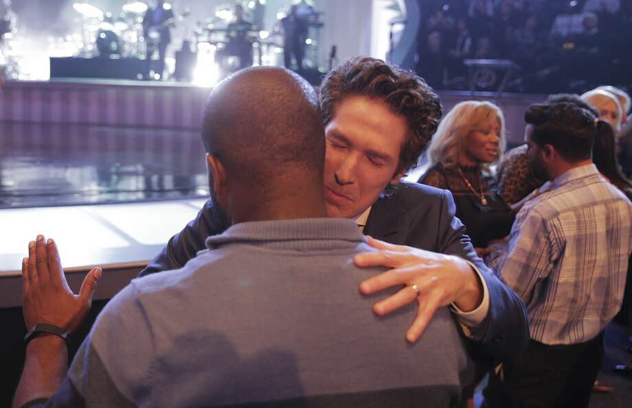 Lakewood pastor Joel Osteen prays with a congregant during service before delivering his sermon. Photo: Elizabeth Conley