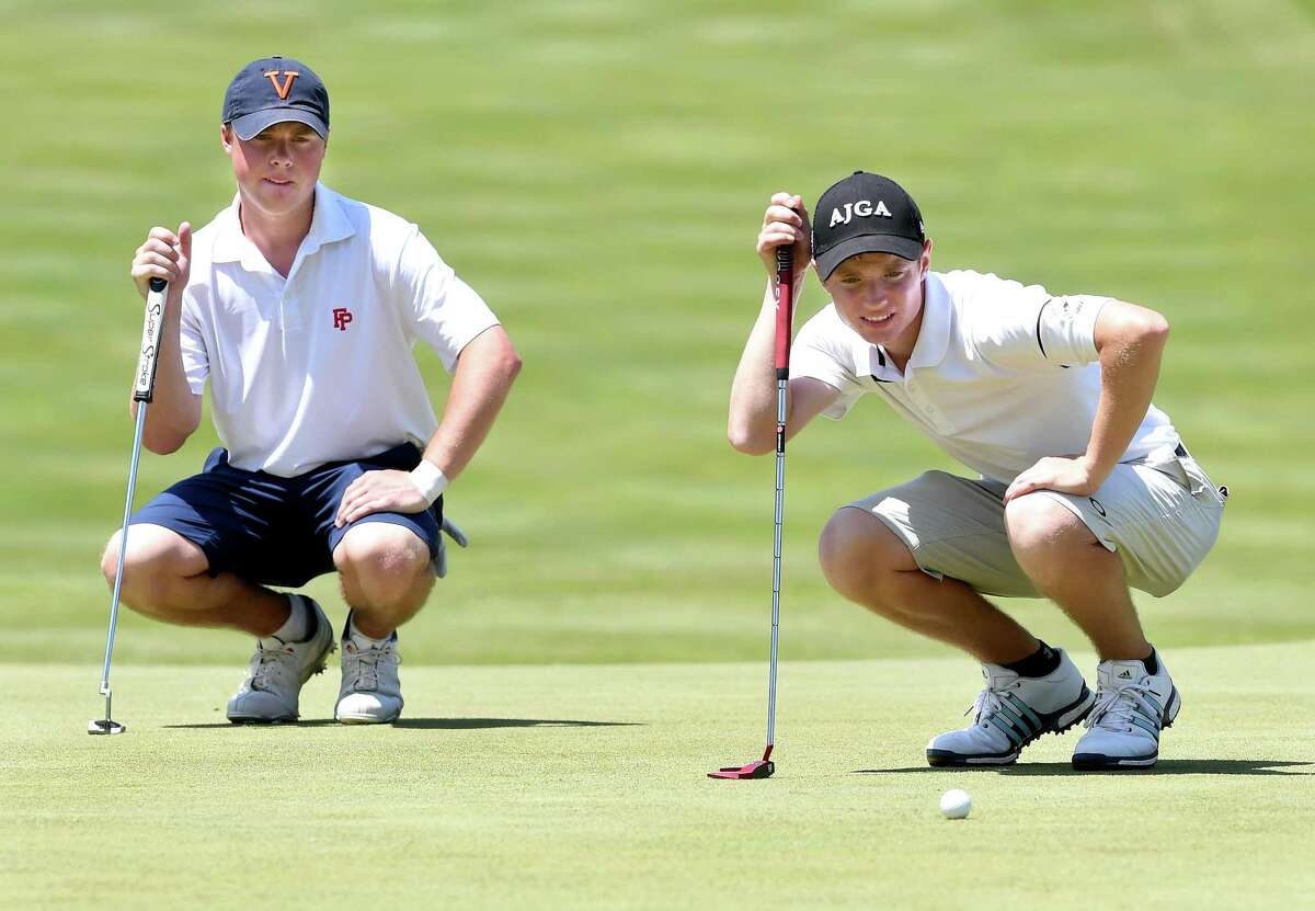 Will Mallek (left), of Fairfield Prep, watches Xavier’s Chris Fosdick line up a putt on hole No. 14 at the Race Brook Country Club in Orange during the SCC golf championship on Tuesday.