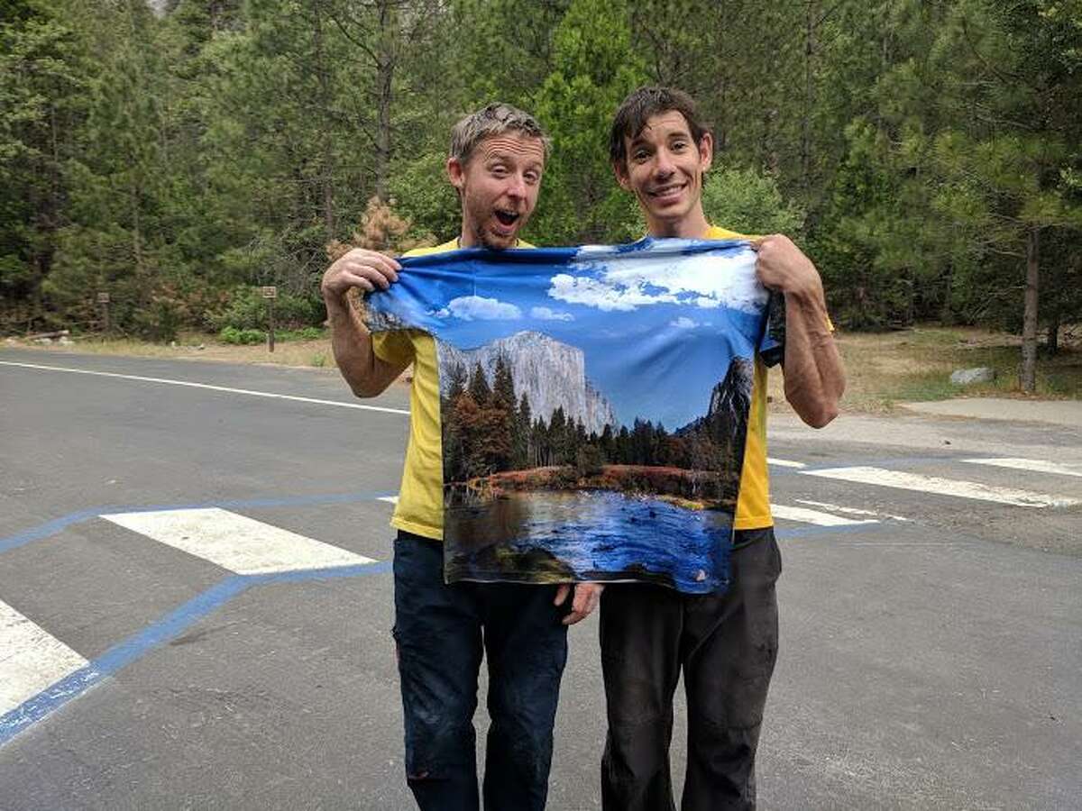 Tommy Caldwell, left, and Alex Honnold, right, hold a t-shirt with an image of the mountain they just climbed as they celebrate their record on the Nose route of El Capitan.