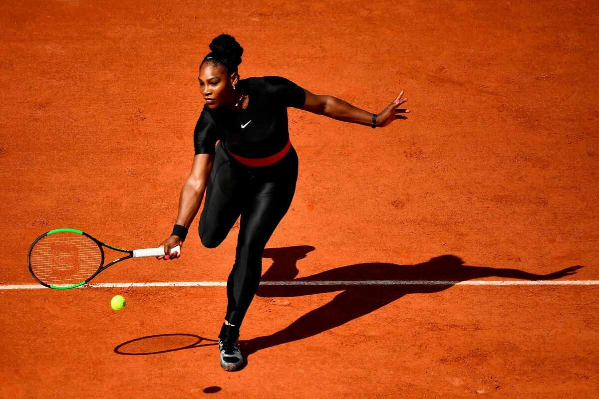 (FILES) In this file photograph taken on May 29, 2018, Serena Williams of the US plays a forehand return to Czech Republic's Kristyna Pliskova during their women's singles first round match on day three of The Roland Garros 2018 French Open tennis tournament in Paris. Serena Williams hit the headlines for her eye-catching, body-hugging black catsuit at the French Open, an outfit she described as "fun and functional", helping her prevent a return of the blood clots which put her life in danger after giving birth last year. / AFP PHOTO / CHRISTOPHE SIMONCHRISTOPHE SIMON/AFP/Getty Images