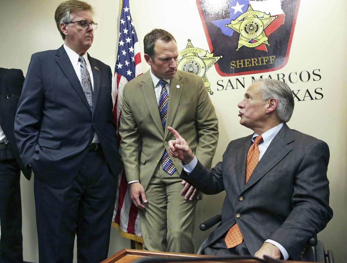 Gov. Greg Abbott discusses plans with Lt. Gov. Dan Patrick, and Rep. Jason Isaac, R-Blanco, after he reveals his school safety proposals at a Wednesday news conference at the Hays County Law Enforcement Center in San Marcos.