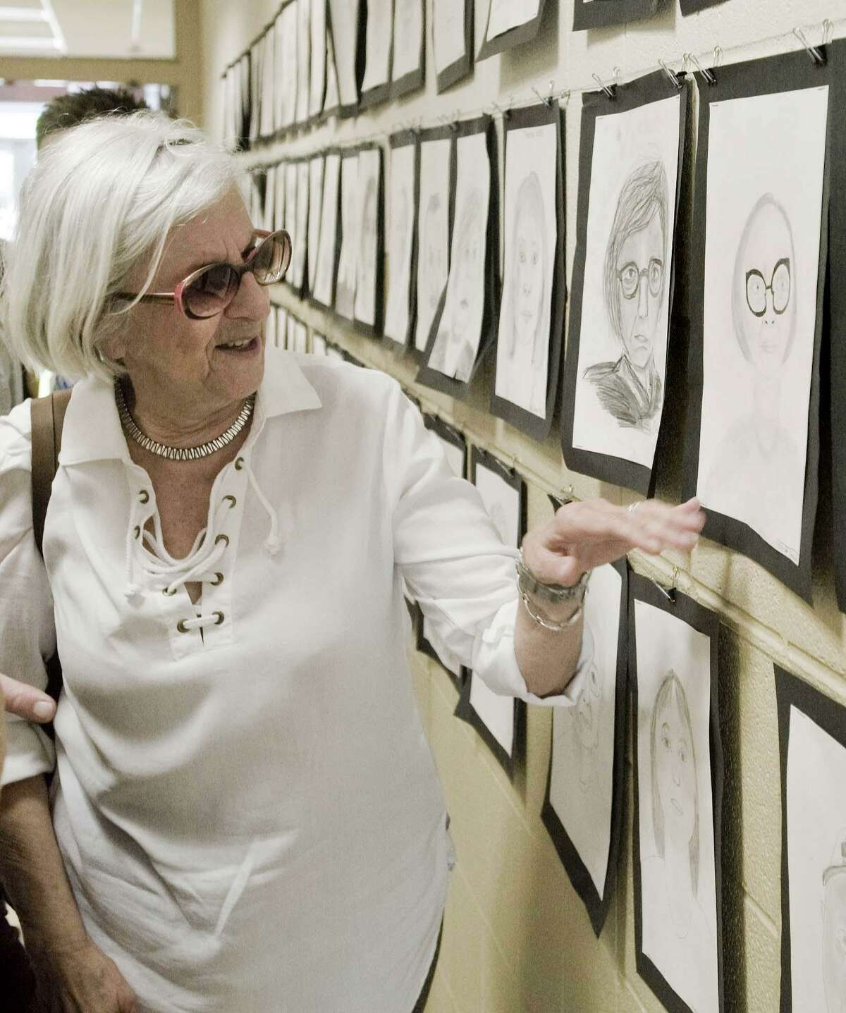 Founders Hall member Clotilde Farrell looks at her portrait drawn by a Scotts Ridge Middle School seventh-grader. Portraits are displayed on the school hallway walls. Wednesday, May 30, 2018