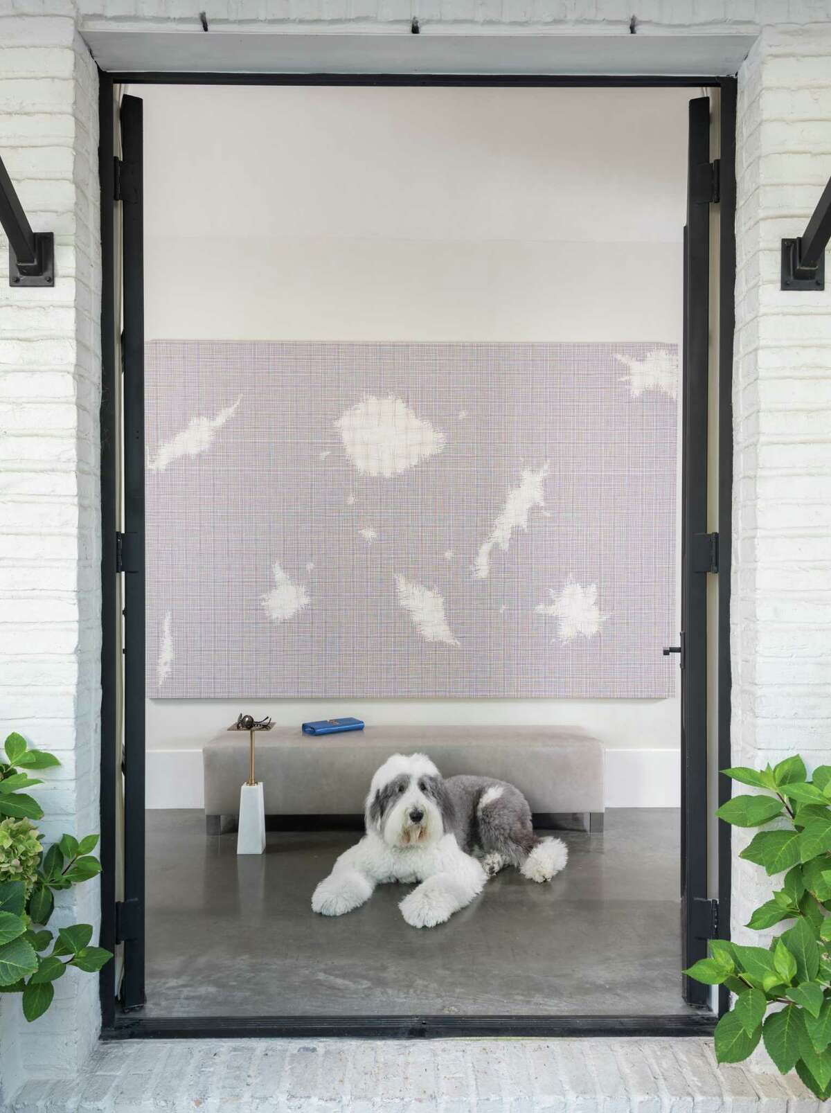 Rocky, the family’s old English sheepdog, greets guests in the foyer.