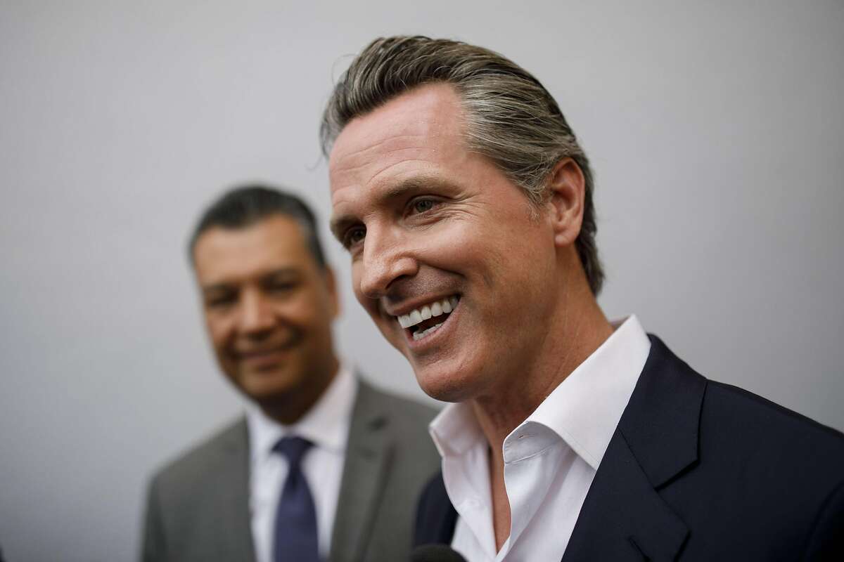 Gavin Newsom, Democratic candidate for governor of California, right, smiles while speaking with members of the media alongside Alex Padilla, California secretary of state, after a rally in Burbank, California, U.S., on Wednesday, May 30, 2018. The Democratic candidates running to replace Governor Jerry Brown -- Lieutenant Governor Newsom, former Los Mayor Antonio Villaraigosa and State Treasurer John Chiang-- have pledged to protect the rights of undocumented immigrants. Photographer: Patrick T. Fallon/Bloomberg