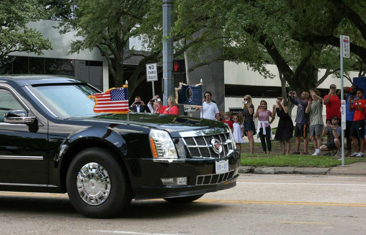 People watch as President Donald Trump’s motorcade leaves The St. Regis Houston hotel after speaking at a National Republican Senatorial Committee lunch Thursday, May 31, 2018, in Houston.