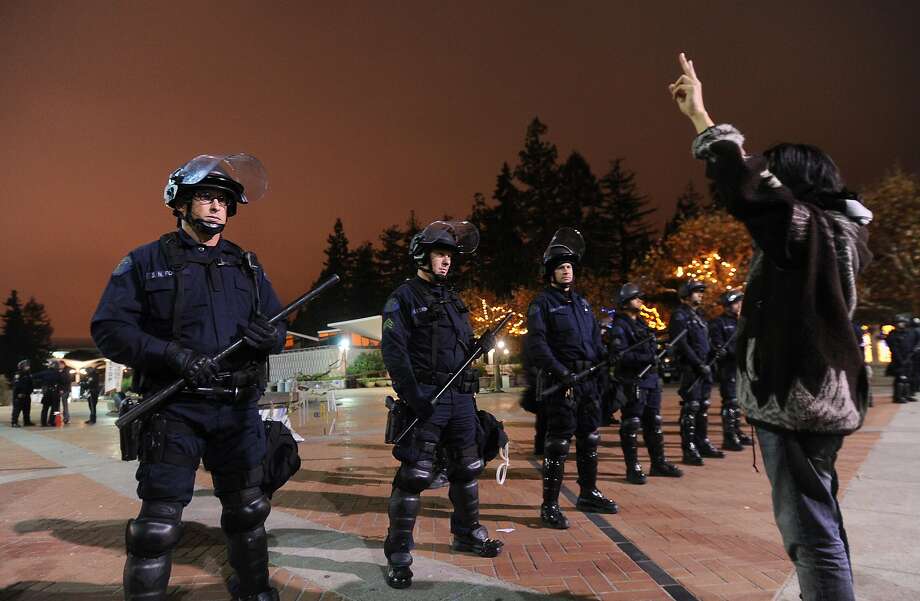 Police surround an Occupy Cal encampment after issuing a five minute warning to vacate on Thursday, Oct. 17, 2011, in Berkeley, Calif. At right, UC Berkeley student Alex Kim was one of two protesters arrested after refusing to leave. Photo: Noah Berger / Special To The Chronicle